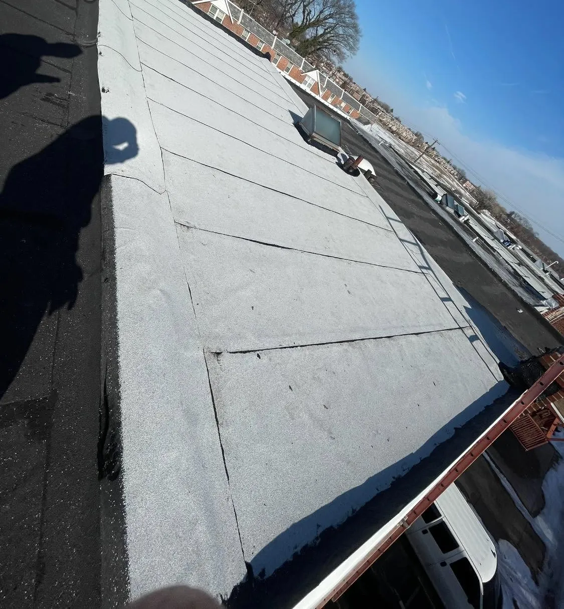 The finished white granulated flat roof with new drip edge metal