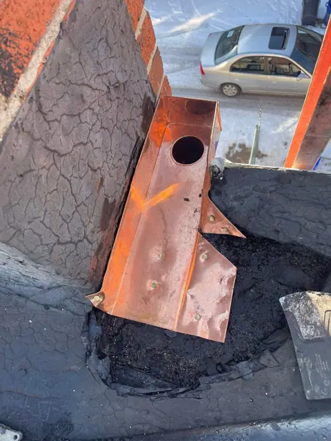 A new copper drain box set into the roof edge
